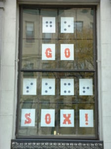 "Go Sox!" spelled out in print and braille letters on large window at NBP